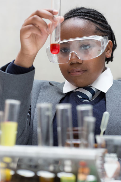 girl in science class wearing goggles